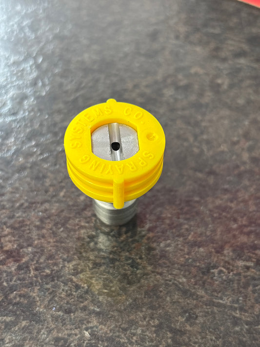 Yellow spray nozzle on a textured gray background