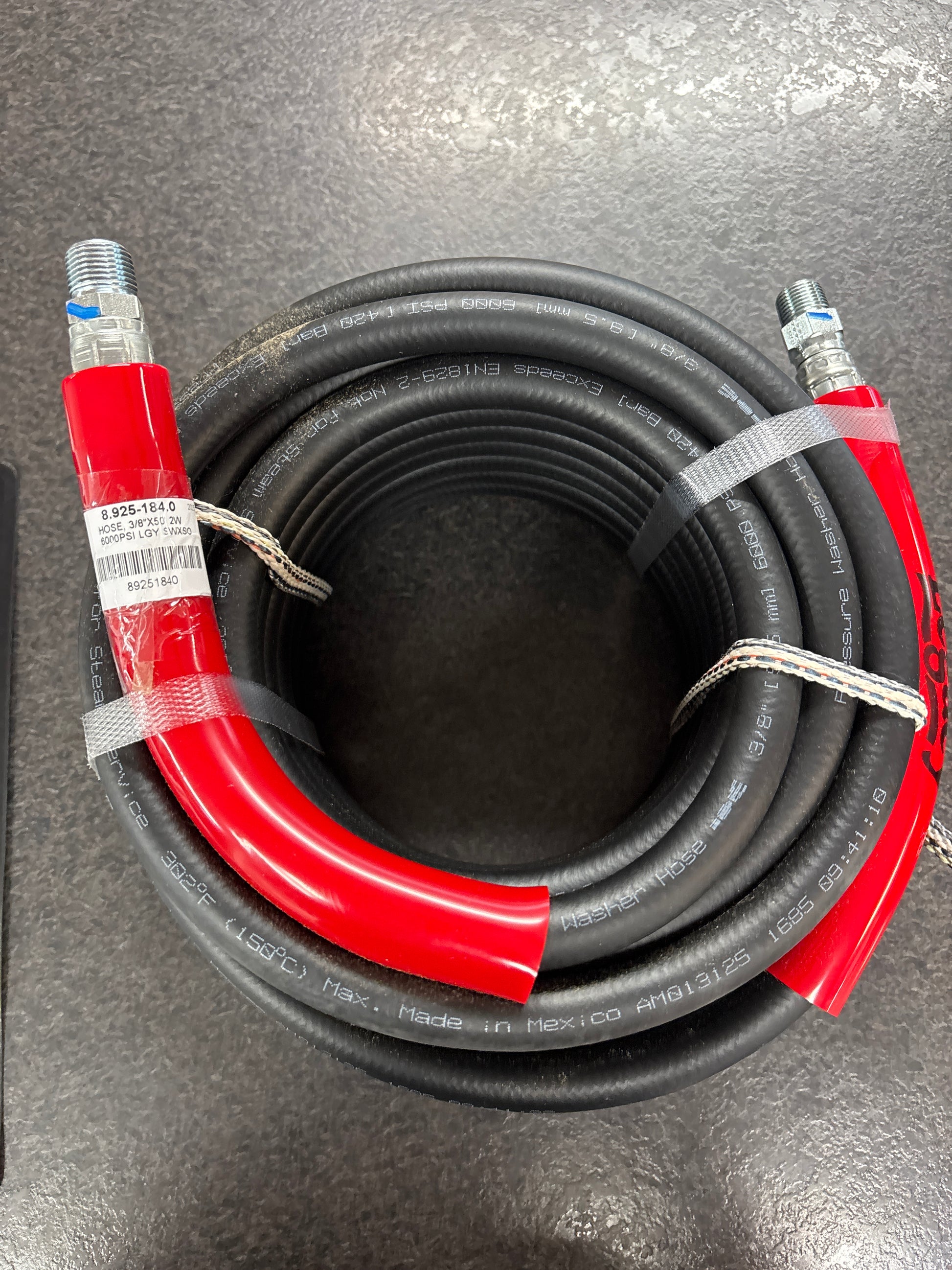 Coiled black and red air hose on a gray surface